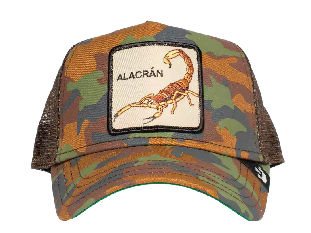 Gorra Goorin Bros con estampado de camuflaje y un parche frontal beige con la imagen de un alacrán.