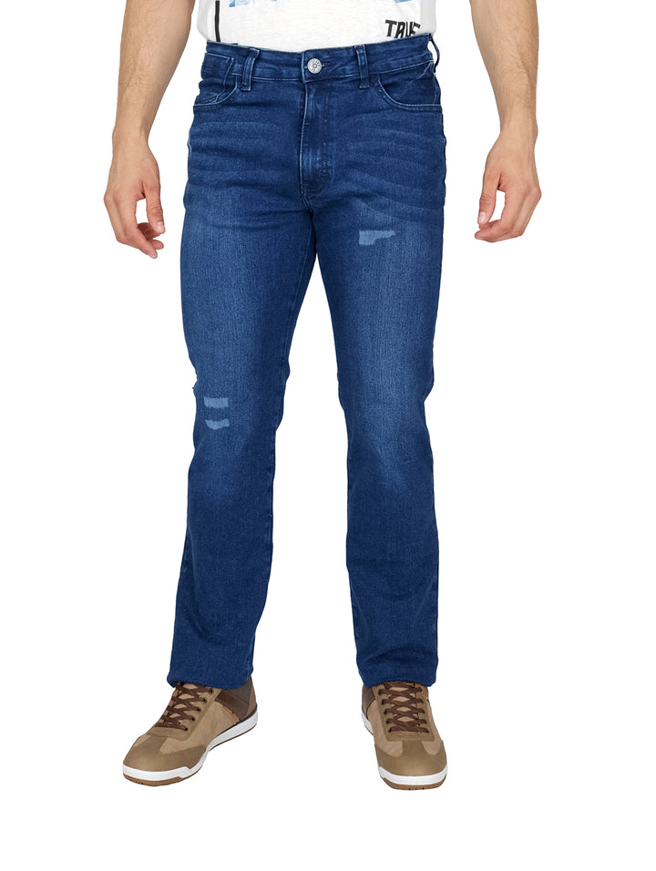 Hombre vistiendo pantalones de mezclilla azules con detalles desgastados y tenis color marrón.
