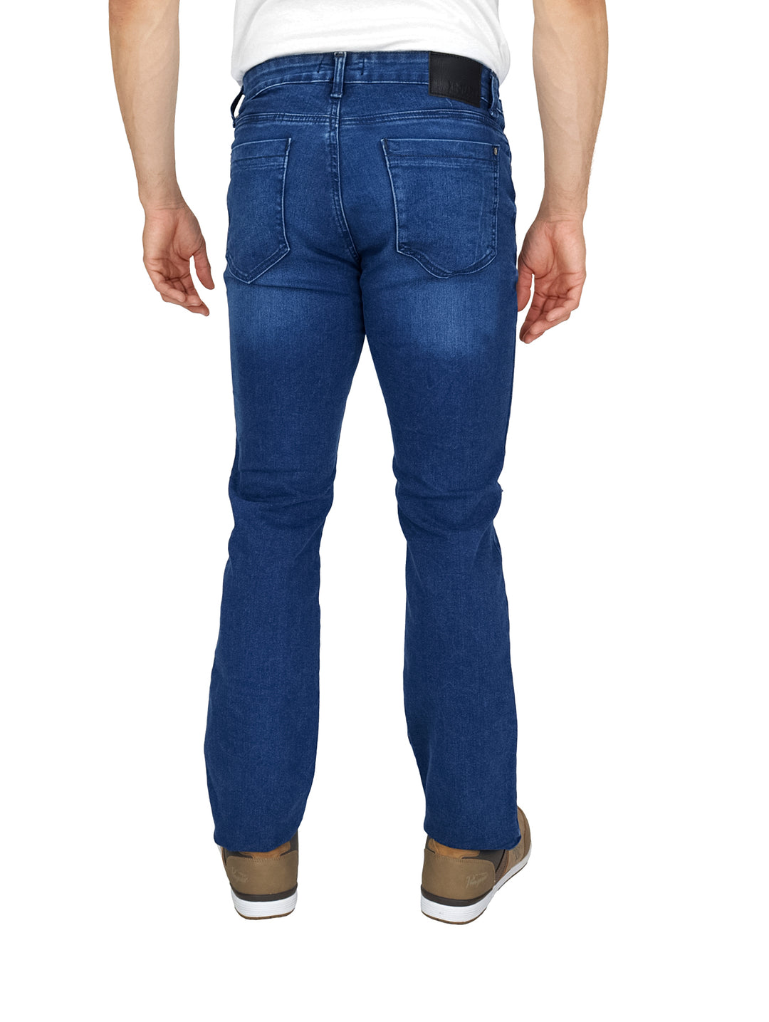 Hombre vistiendo pantalones de mezclilla azules con detalles desgastados y tenis color marrón.