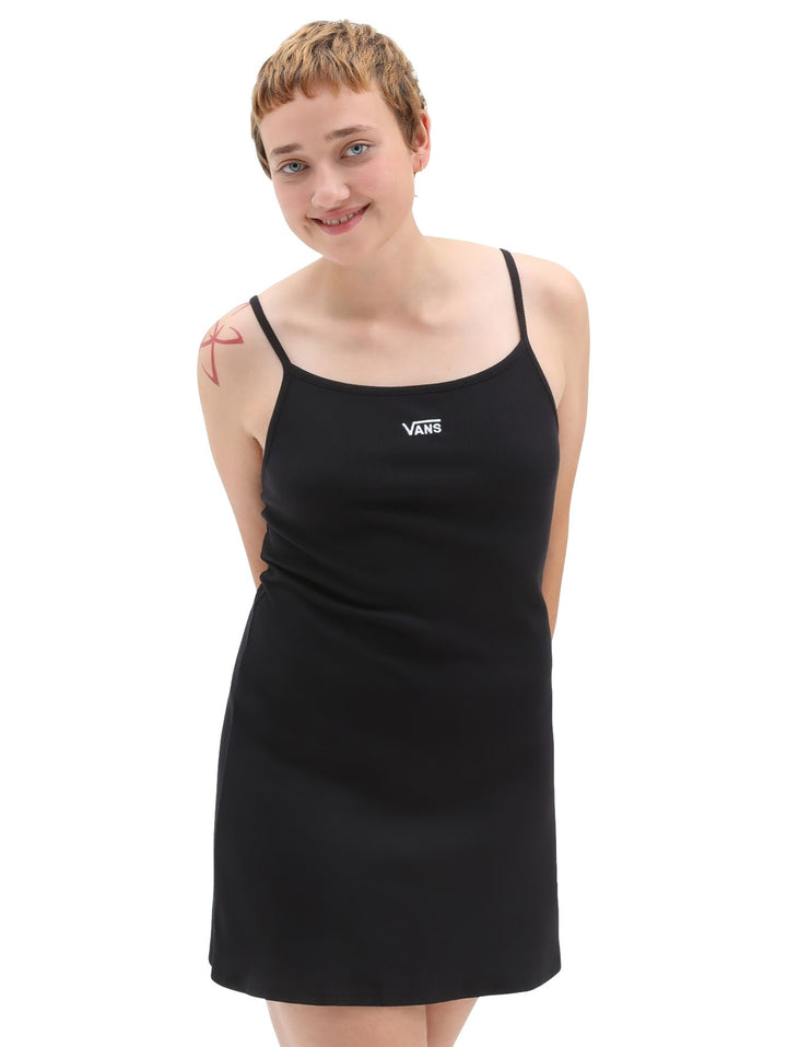 Mujer vistiendo un vestido corto negro de tirantes con el logotipo de Vans en blanco en el pecho.