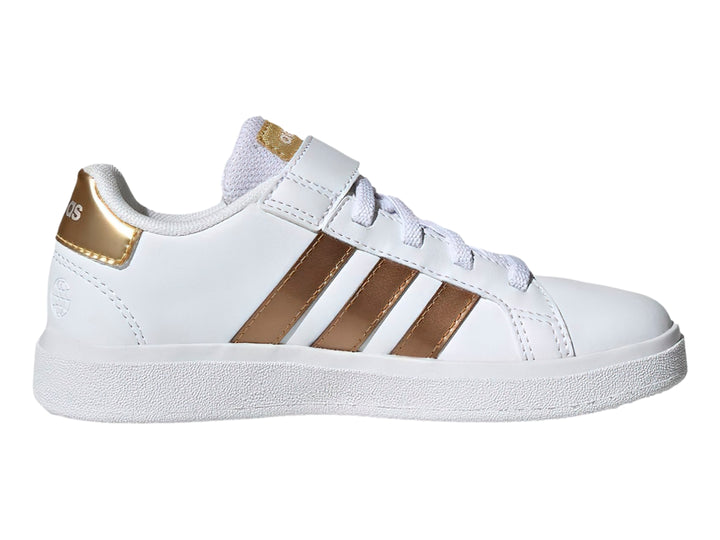 Tenis Adidas blancos con tres franjas doradas y cierre de velcro.