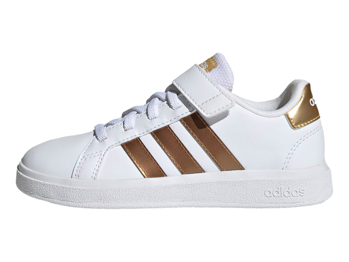 Tenis Adidas blancos con tres franjas doradas y cierre de velcro.