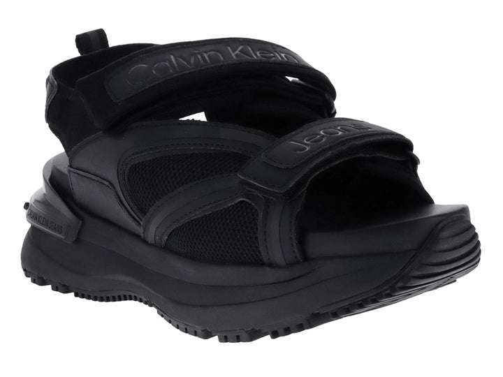 Sandalia negra de plataforma Calvin Klein con correas ajustables y suela gruesa.