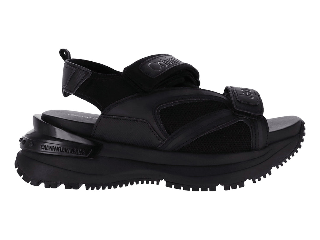 Sandalia negra de plataforma Calvin Klein con correas ajustables y suela gruesa.