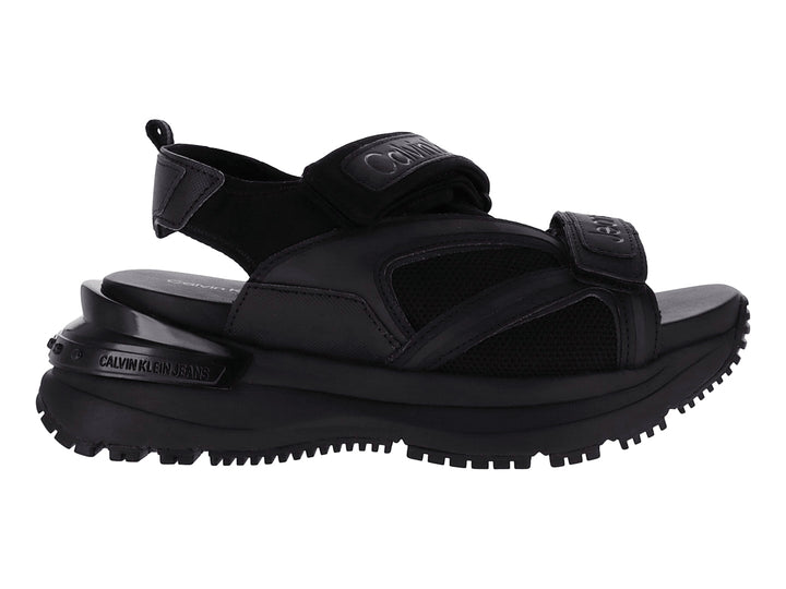 Sandalia negra de plataforma Calvin Klein con correas ajustables y suela gruesa.