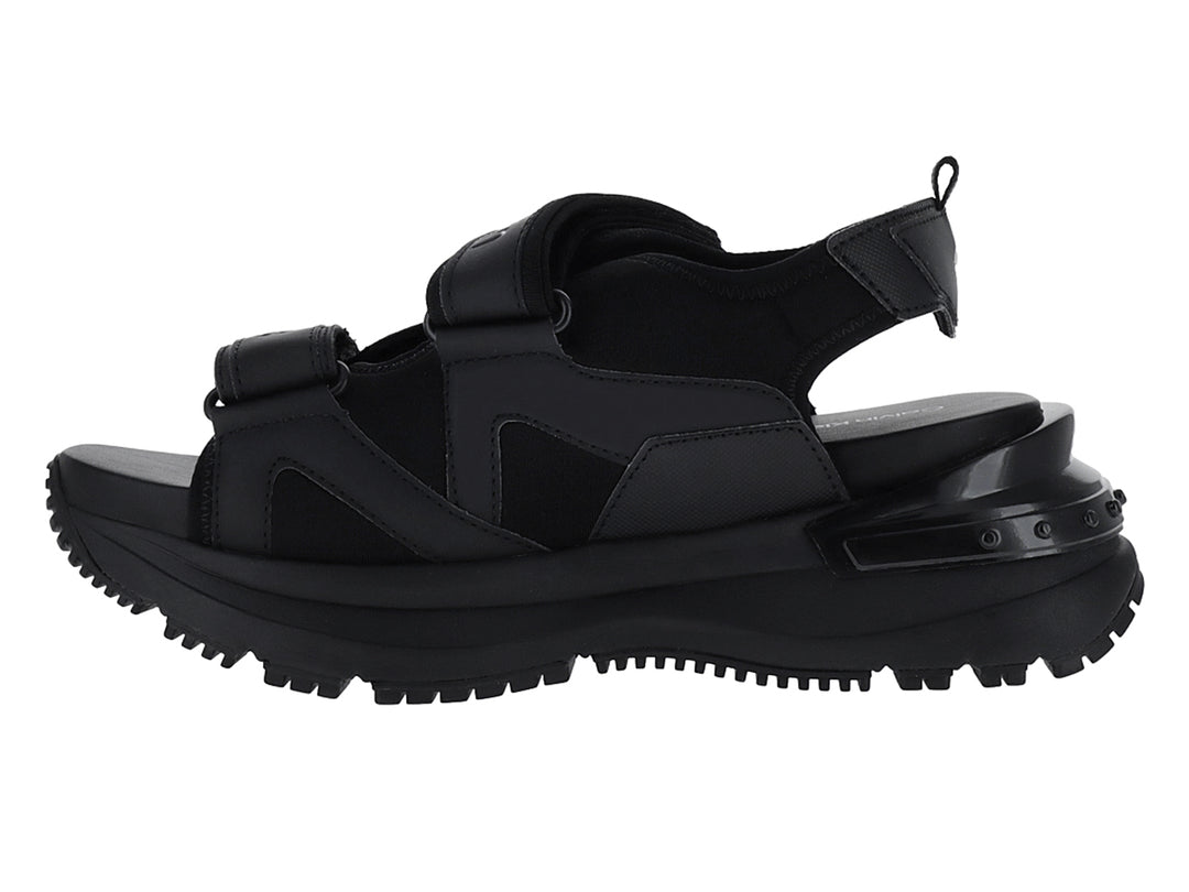Sandalia negra de plataforma Calvin Klein con correas ajustables y suela gruesa.