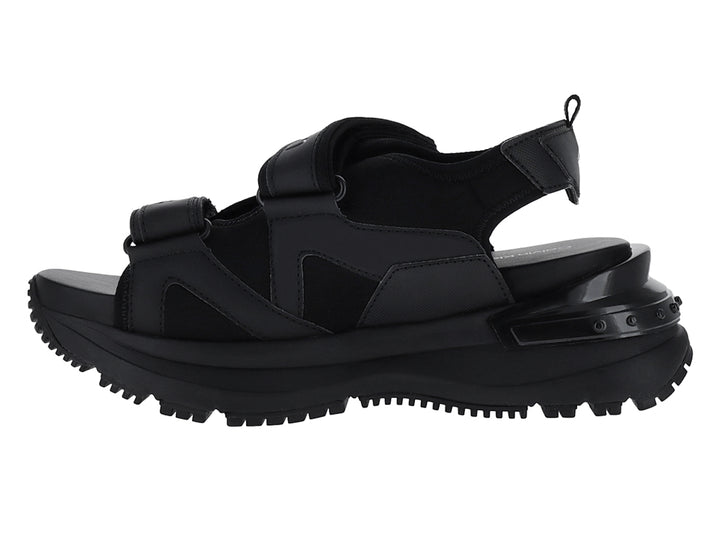 Sandalia negra de plataforma Calvin Klein con correas ajustables y suela gruesa.