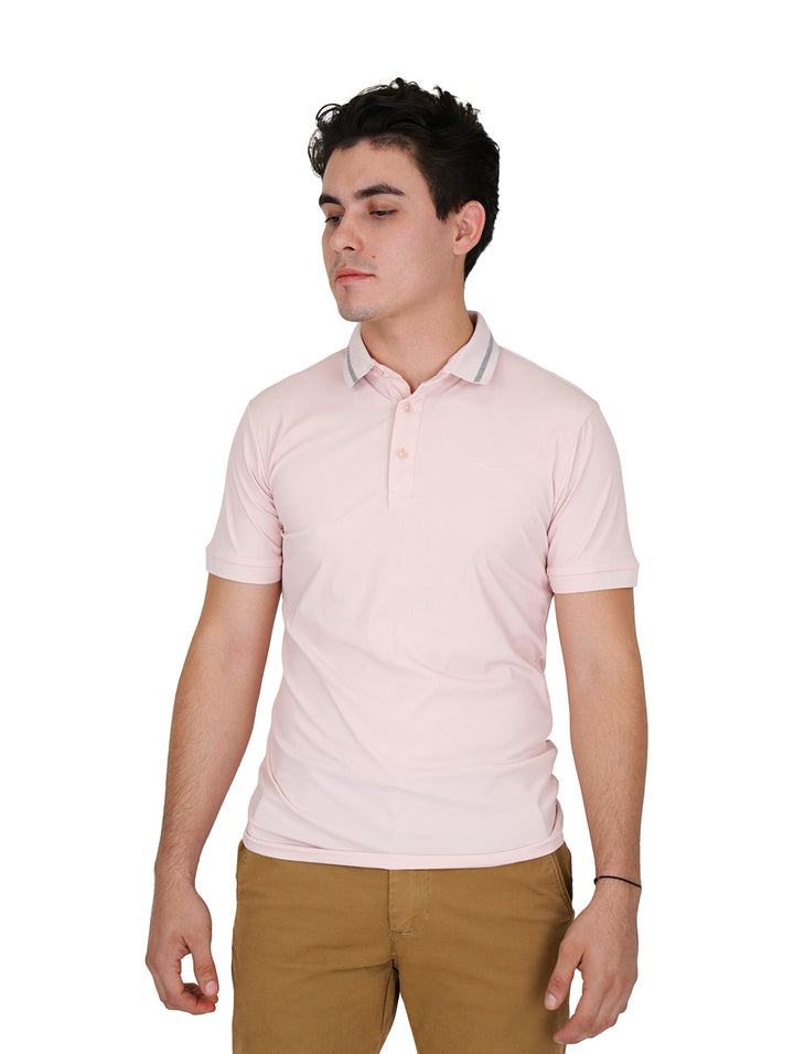 Hombre vistiendo una playera tipo polo de color rosa claro con cuello detallado y pantalones color caqui.