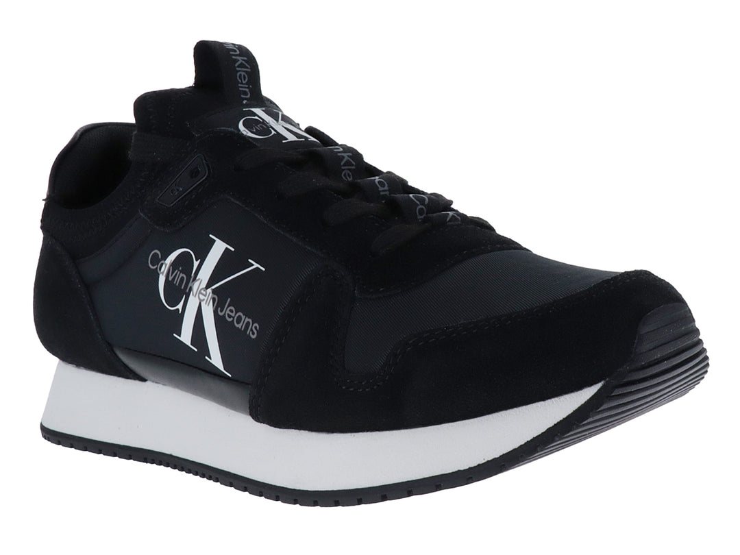 Tenis deportivos Calvin Klein color negro con suela blanca y logotipo blanco en el lateral.