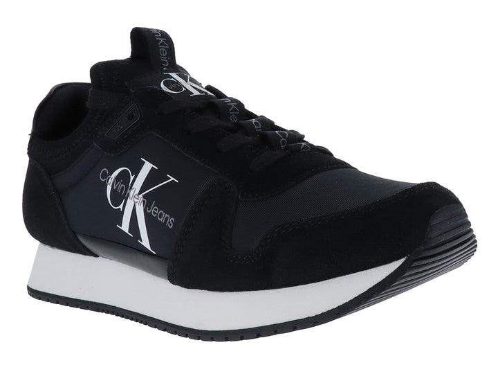 Tenis deportivos Calvin Klein color negro con suela blanca y logotipo blanco en el lateral.