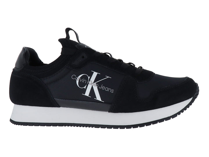 Tenis deportivos Calvin Klein color negro con suela blanca y logotipo blanco en el lateral.