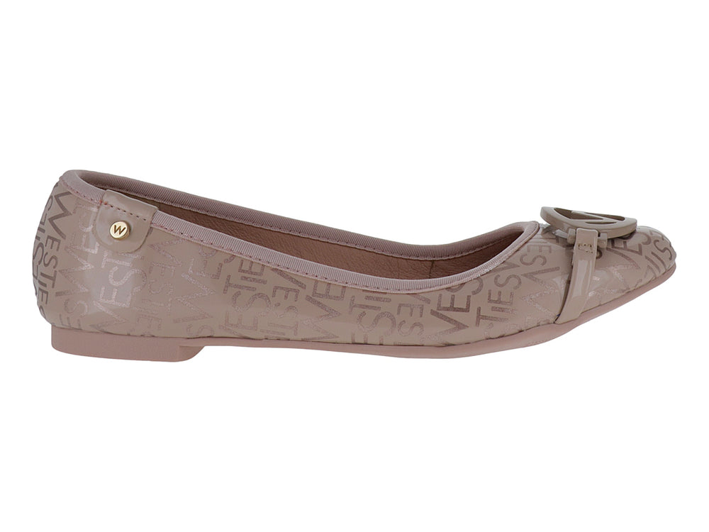Zapato plano color nude con monograma grabado y adorno frontal circular.