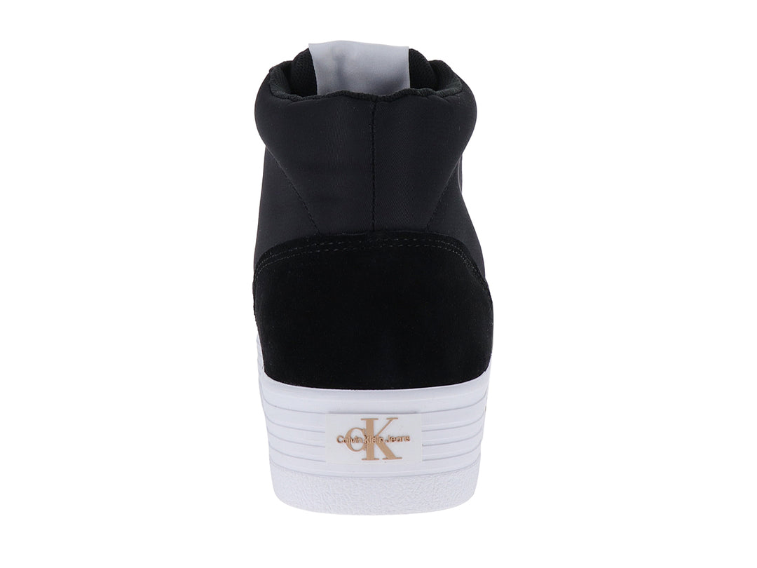 Tenis botín Calvin Klein color negro con suela blanca y detalles dorados.