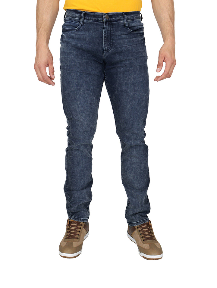 Hombre vistiendo pantalones Lee de mezclilla color índigo en corte slim fit.