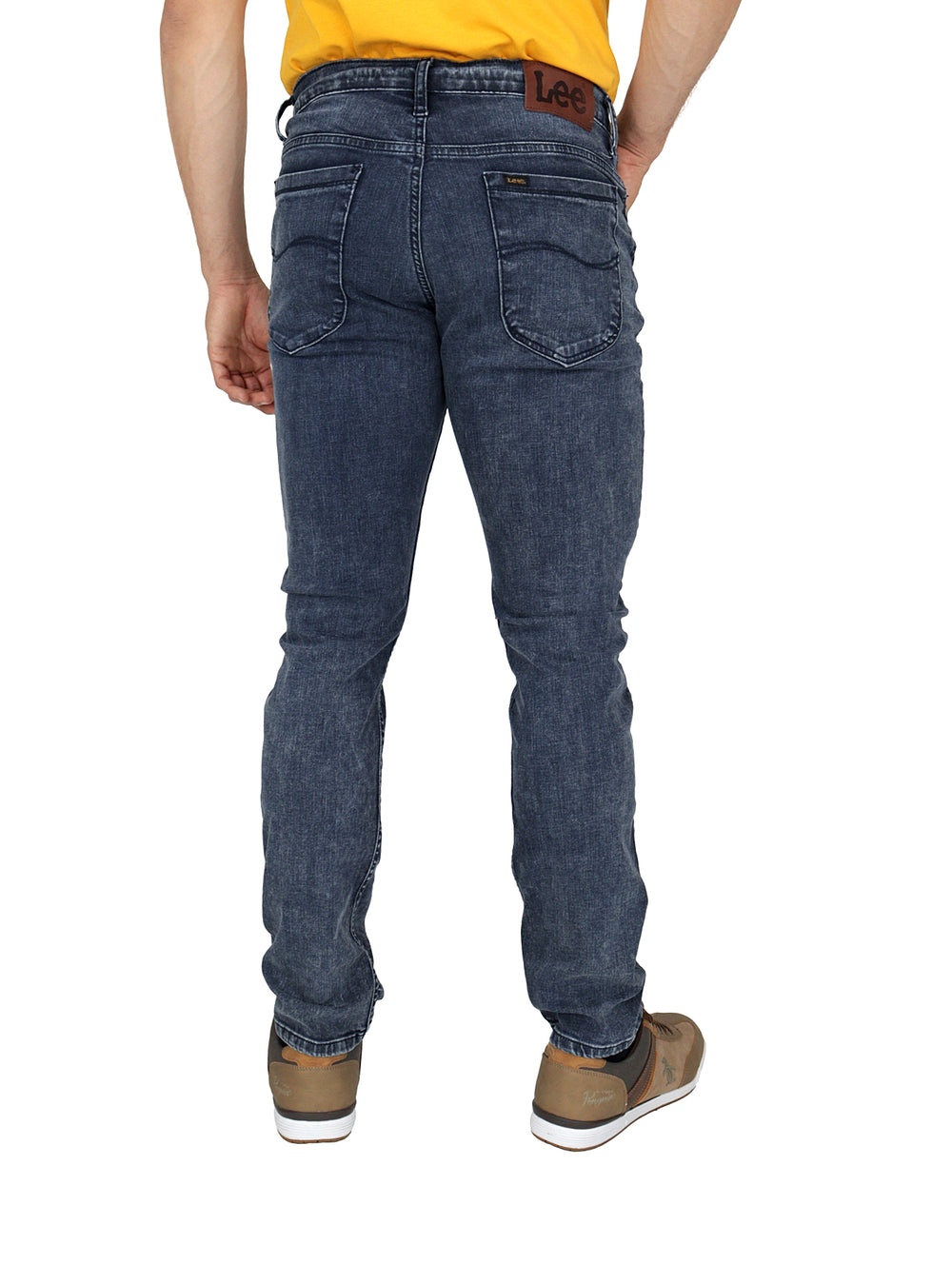 Hombre vistiendo pantalones Lee de mezclilla color índigo en corte slim fit.