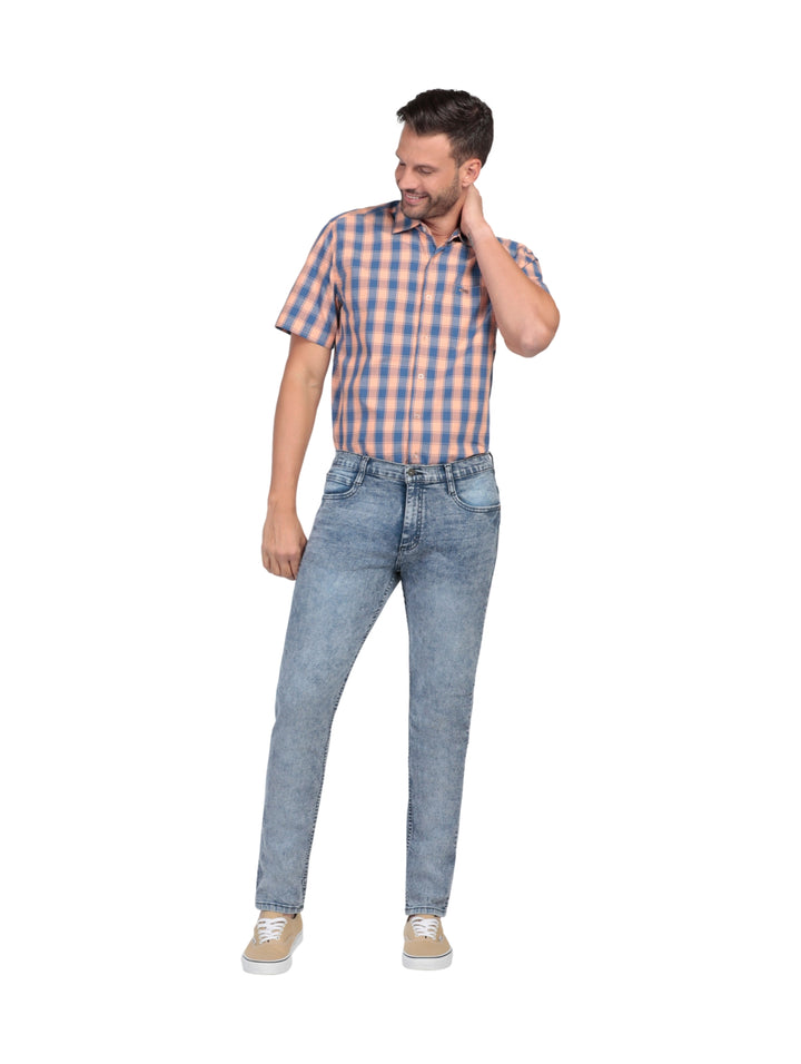 Hombre vistiendo pantalones Lee de mezclilla color índigo en corte slim fit.