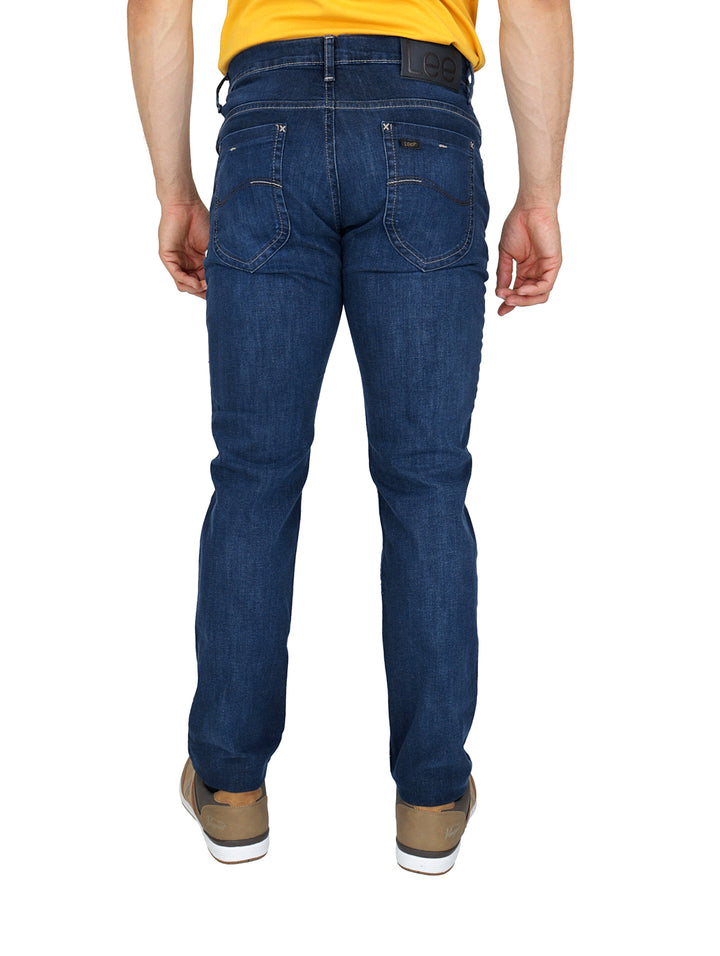 Hombre vistiendo pantalones LEE skinny jeans en color azul indigo.