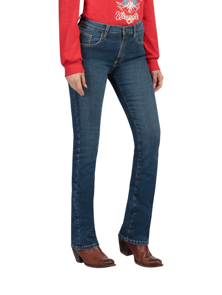 Mujer vistiendo jeans Wrangler de color índigo claro y corte recto con botas cafés.
