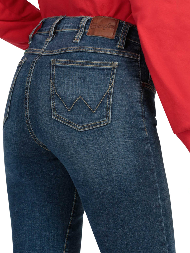 Mujer vistiendo jeans Wrangler de color índigo claro y corte recto con botas cafés.
