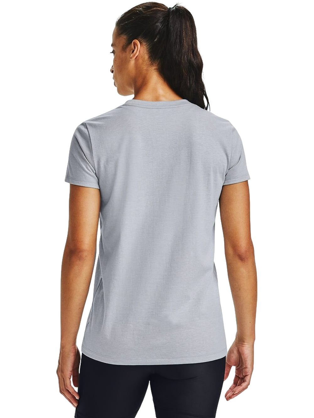 Mujer vistiendo playera Under Armour de color gris con logotipo negro en el pecho y shorts deportivos negros.