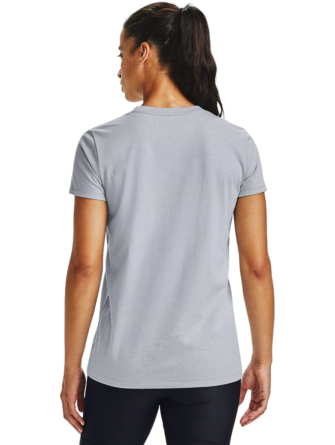 Mujer vistiendo playera Under Armour de color gris con logotipo negro en el pecho y shorts deportivos negros.