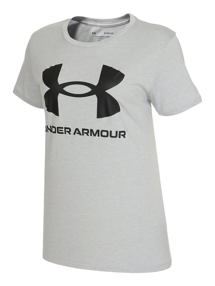 Mujer vistiendo playera Under Armour de color gris con logotipo negro en el pecho y shorts deportivos negros.
