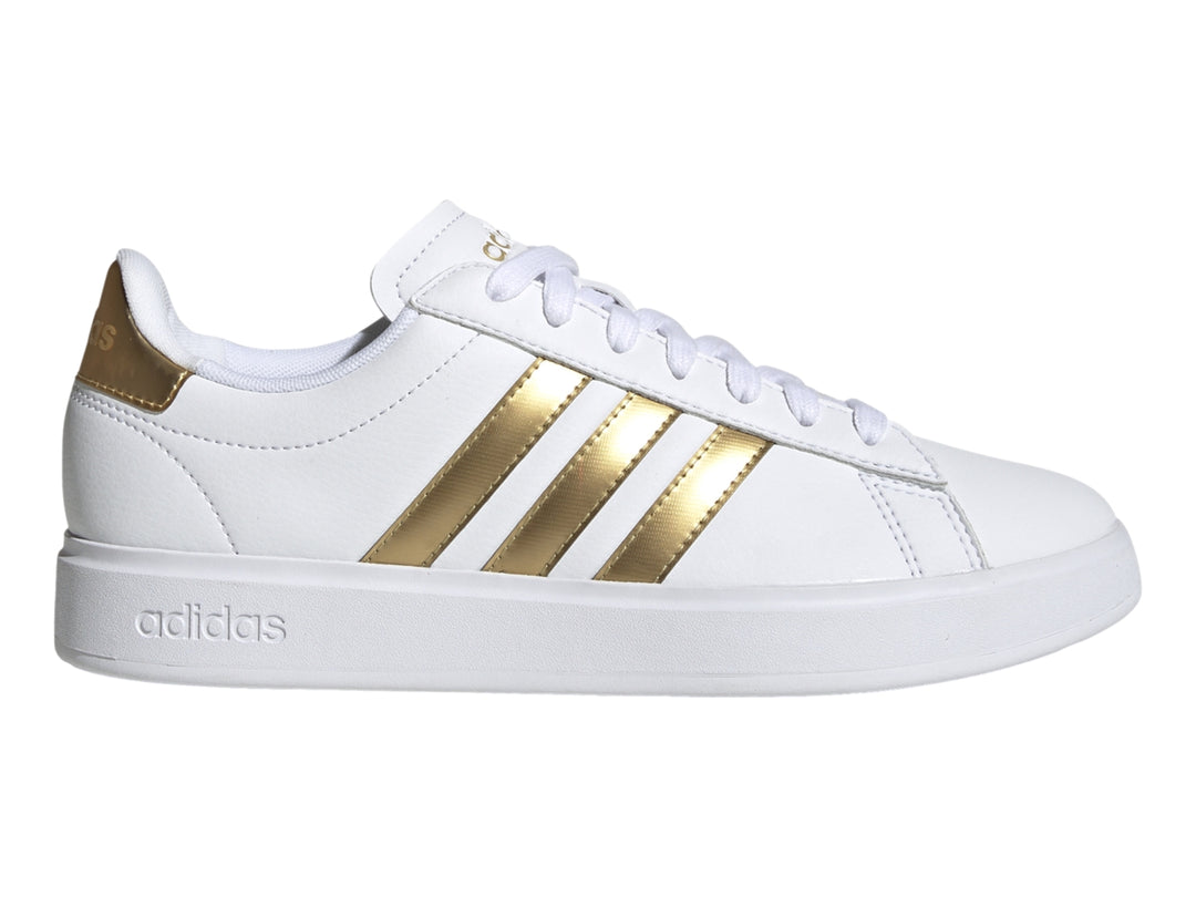 Tenis Adidas Grand Court color blanco con tres franjas laterales y detalle en el talón en color dorado.