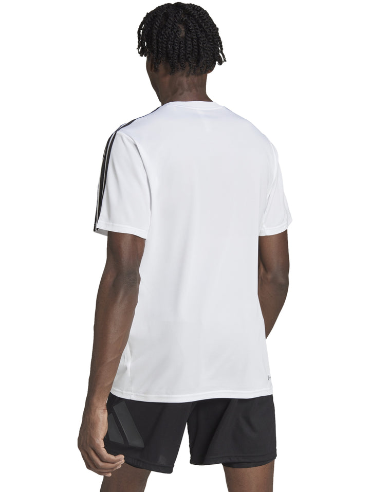 Hombre vistiendo camiseta Adidas blanca con tres franjas negras en los hombros y logo negro en el pecho.