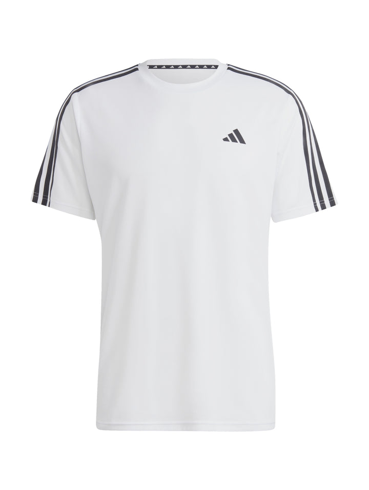 Hombre vistiendo camiseta Adidas blanca con tres franjas negras en los hombros y logo negro en el pecho.