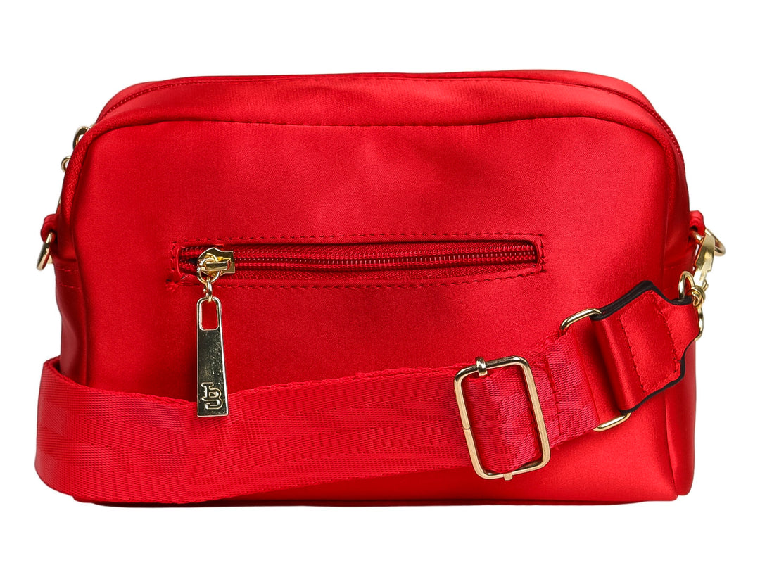 Bolso de nylon color rojo con logotipo circular dorado en el centro y forma rectangular redondeada.