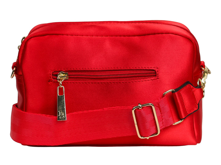 Bolso de nylon color rojo con logotipo circular dorado en el centro y forma rectangular redondeada.