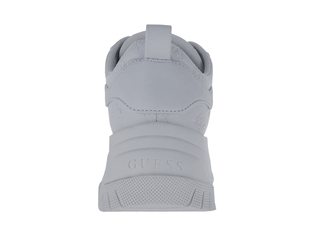Tenis blancos de plataforma marca GUESS con suela gruesa y detalles en relieve sobre el material.