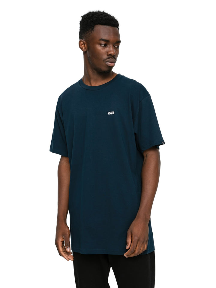 Hombre vistiendo una camiseta de manga corta color azul marino con un pequeño logotipo blanco de Vans en el pecho.