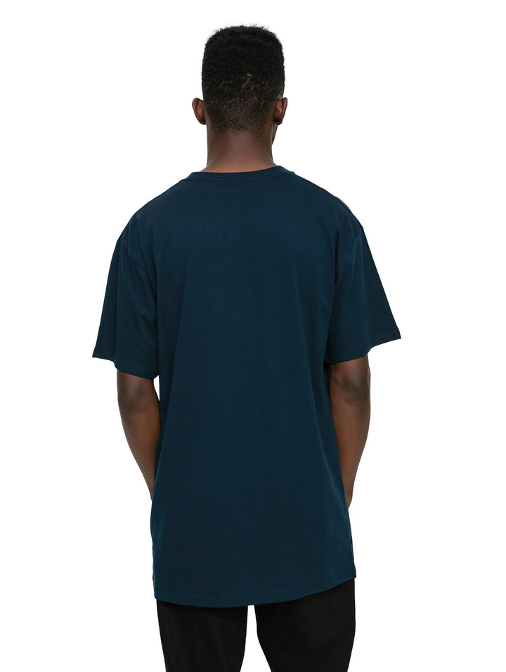 Hombre vistiendo una camiseta de manga corta color azul marino con un pequeño logotipo blanco de Vans en el pecho.