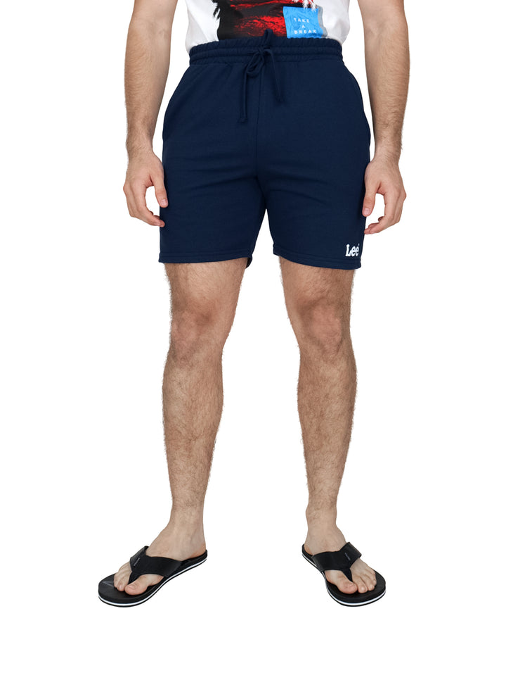 Hombre vistiendo bermudas color azul marino marca Lee con cintura elástica y cordón.