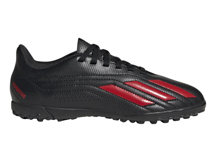 Calzado de fútbol Adidas negro con franjas rojas y suela para césped sintético.