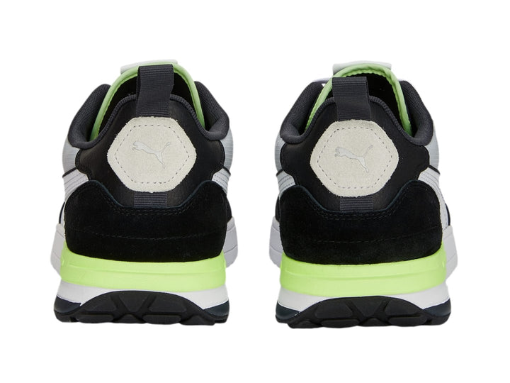 Tenis PUMA R22 en colores negro, gris y blanco con detalles en amarillo neón, vista lateral.
