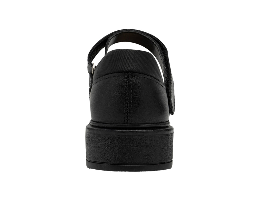Zapato escolar negro para niña con correa y detalle decorativo en la punta.