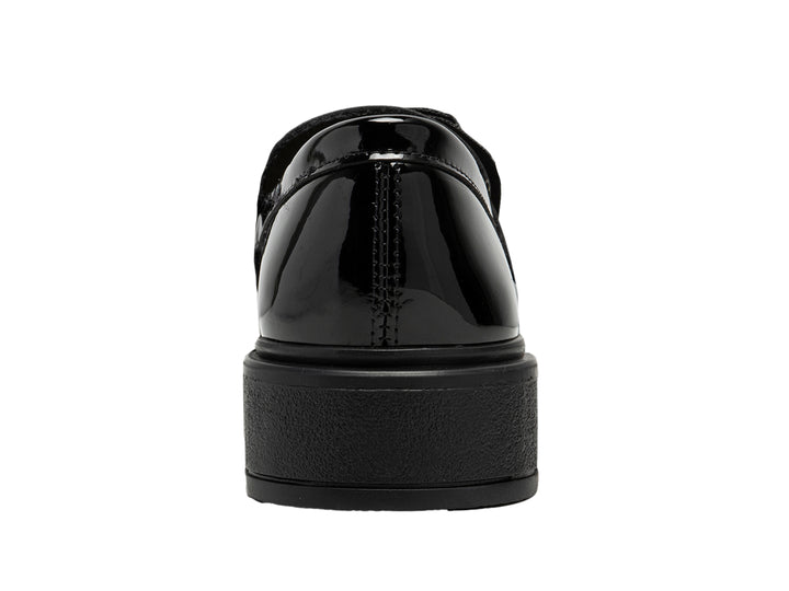 Zapato infantil de charol negro brillante con moño decorativo y suela gruesa.