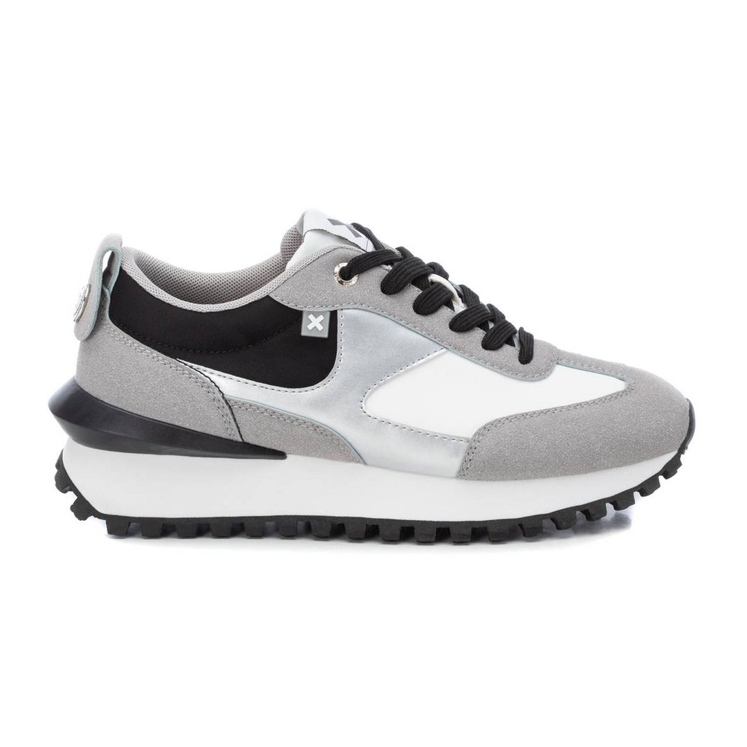 Tenis deportivos XTI en colores gris, blanco y negro con suela dentada.