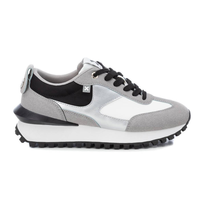 Tenis deportivos XTI en colores gris, blanco y negro con suela dentada.