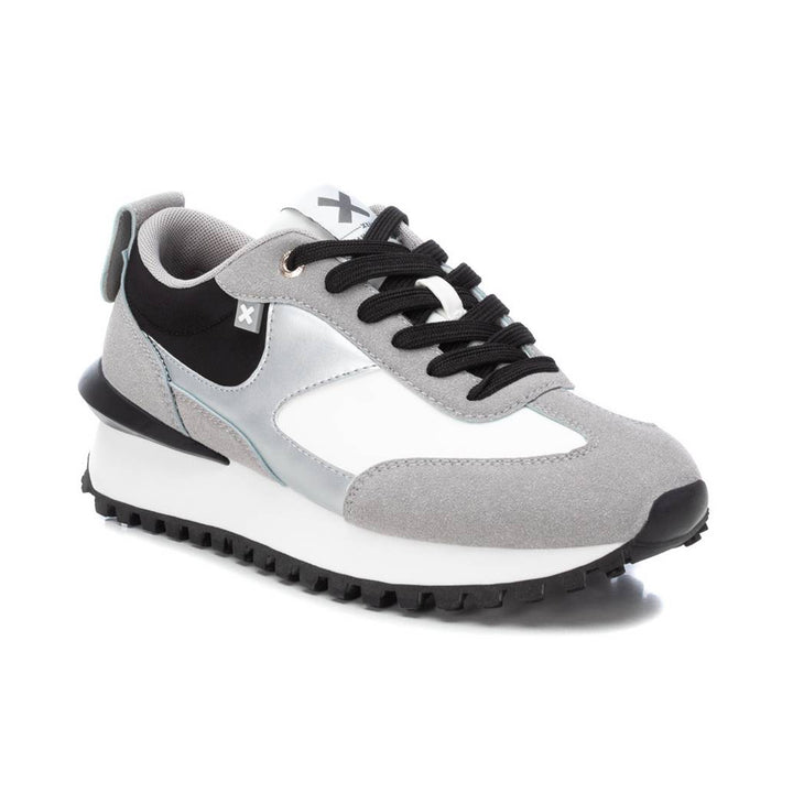 Tenis deportivos XTI en colores gris, blanco y negro con suela dentada.