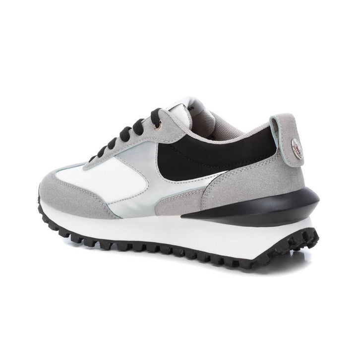 Tenis deportivos XTI en colores gris, blanco y negro con suela dentada.