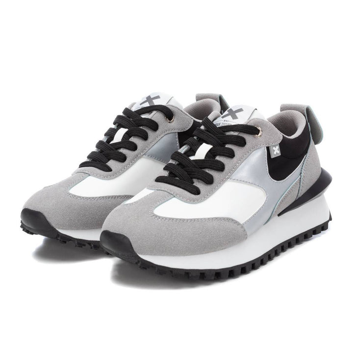 Tenis deportivos XTI en colores gris, blanco y negro con suela dentada.