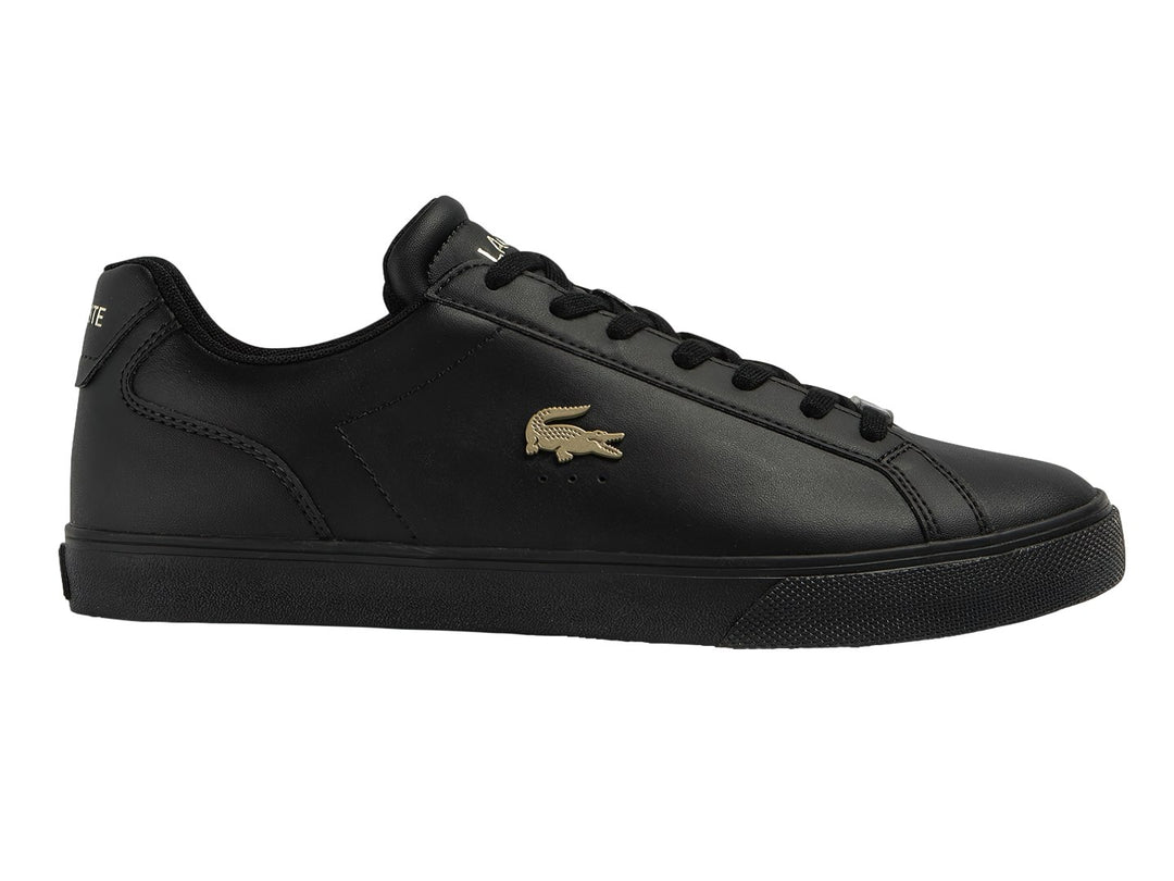 Tenis Lacoste color negro con logotipo dorado en el lateral y suela negra.
