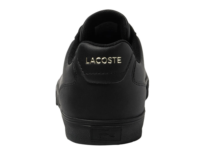 Tenis Lacoste color negro con logotipo dorado en el lateral y suela negra.