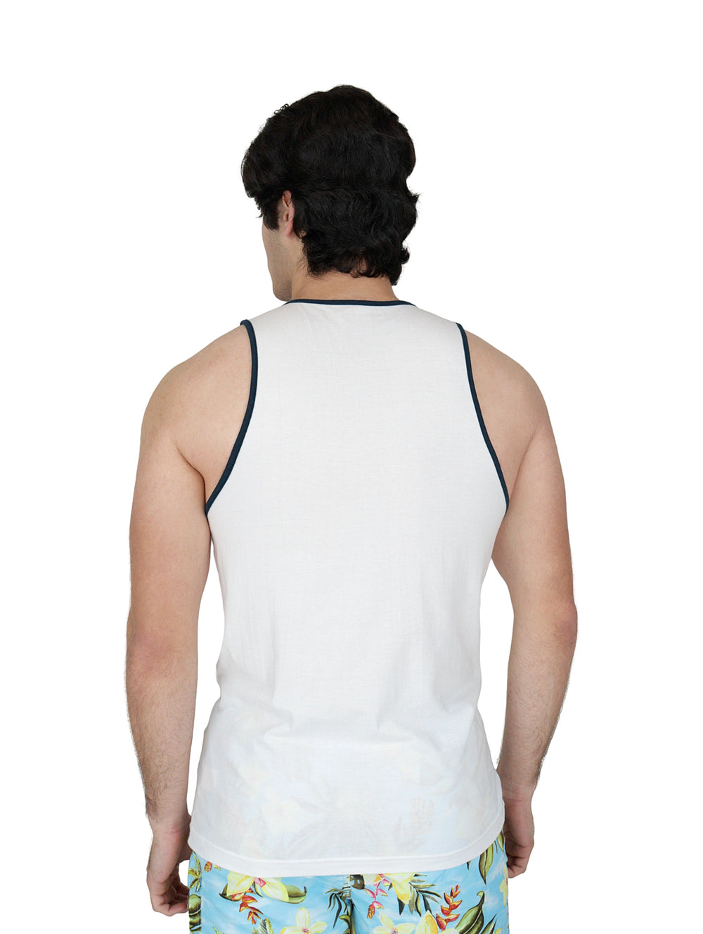 Hombre vistiendo playera tank blanca con estampado de playa y shorts florales.