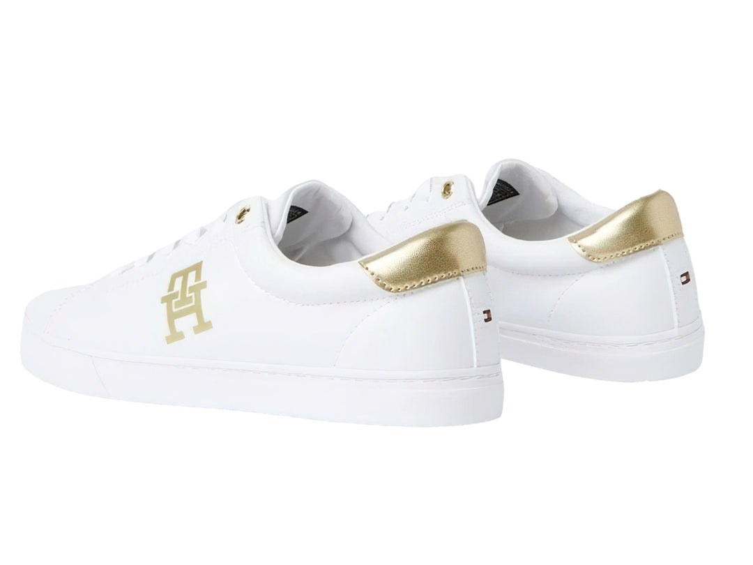 Tenis Tommy Hilfiger color blanco con detalles y logotipo en dorado, diseño casual de perfil bajo.