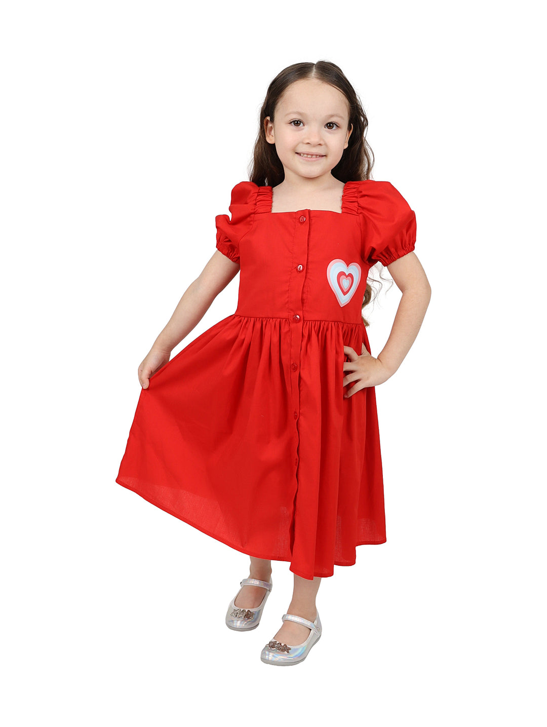 Niña vistiendo un vestido rojo de popelina con botones frontales y un detalle de corazón blanco.