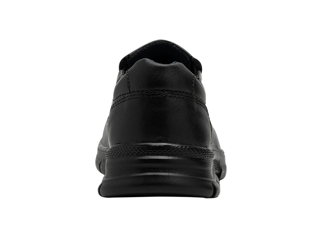 Zapato negro estilo slip-on para niño, material sintético y suela gruesa.